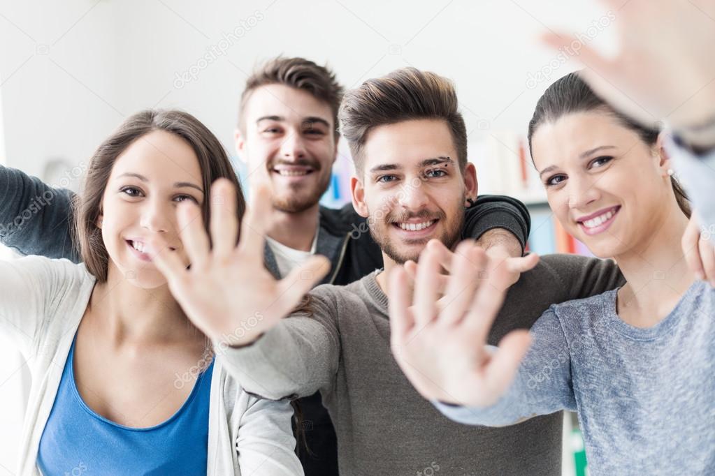 friends posing and greeting with hands up