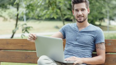  parkta bir dizüstü bilgisayar kullanan adam