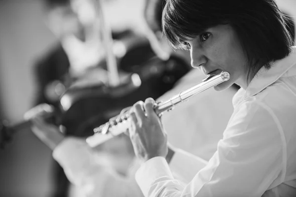 Fluitist spelen haar instrument op het podium — Stockfoto