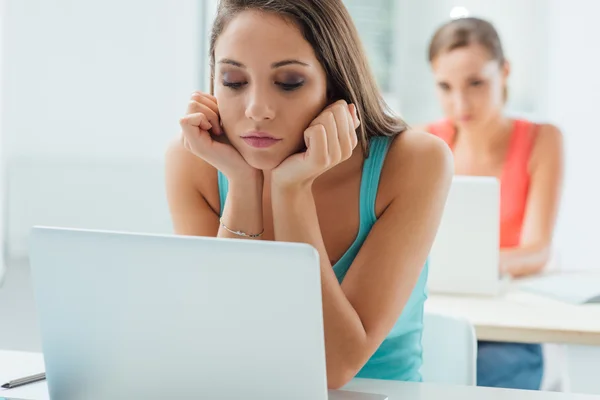 Fille ennuyée assise au bureau de l'école — Photo