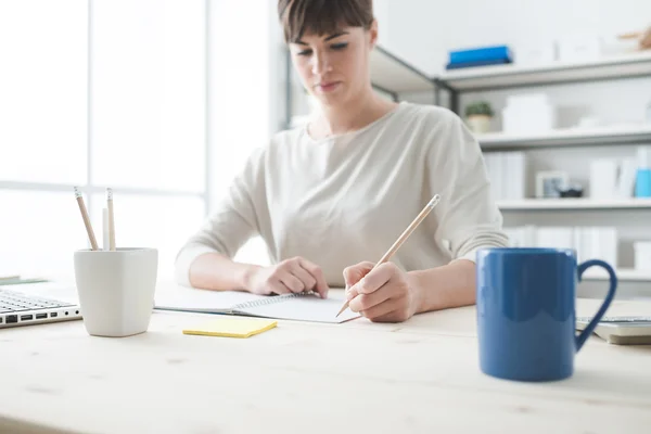 Young woman sketching on a notebook — Stock Photo, Image