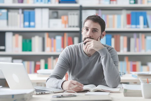 Junger Mann sitzt am Schreibtisch — Stockfoto