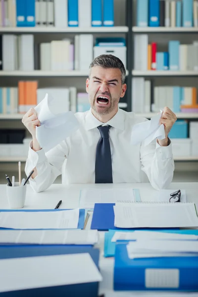 Homem de negócios irritado trabalhando na mesa de escritório — Fotografia de Stock