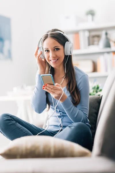 Leende kvinna lyssnar på musik — Stockfoto