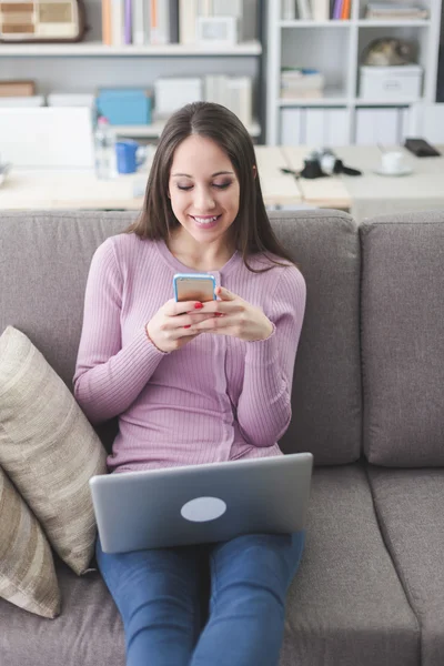 Kvinna textilen med sin smartphone — Stockfoto