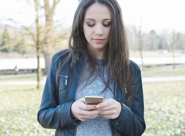 Žena textilie s její smartphone — Stock fotografie