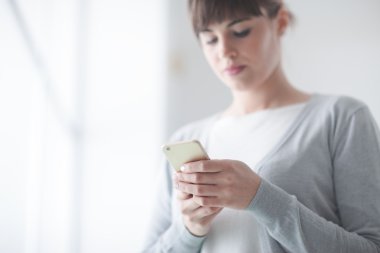 Genç kadın kısa onun cep telefonu ile mesaj