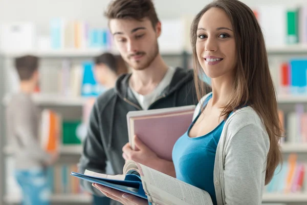 Šťastní studenti v knihovně — Stock fotografie