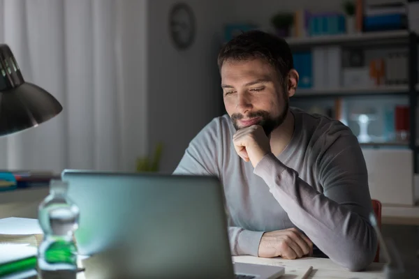 Hombre usando un portátil tarde en la noche — Foto de Stock