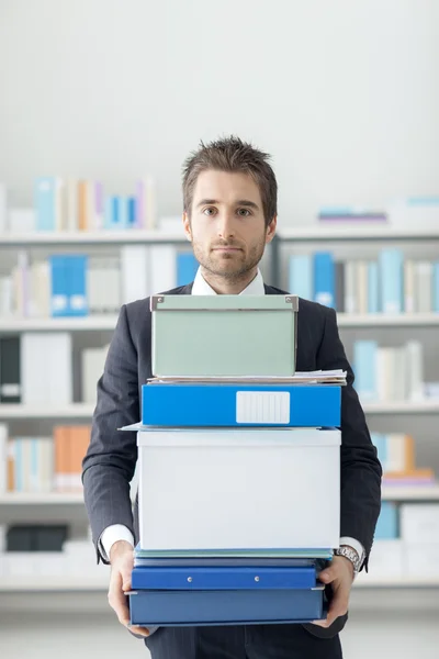 Zakenman die een stapel dozen en mappen — Stockfoto