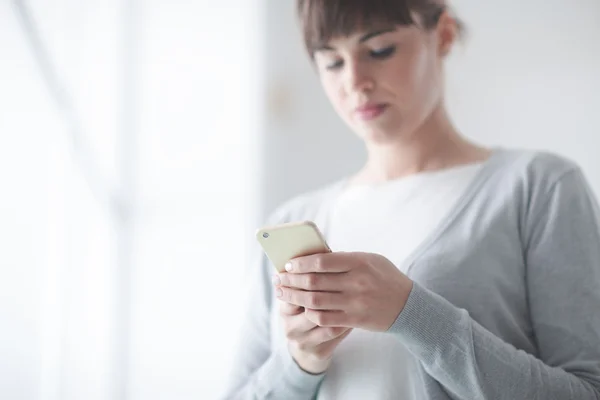 Junge Frau SMS mit ihrem Handy — Stockfoto