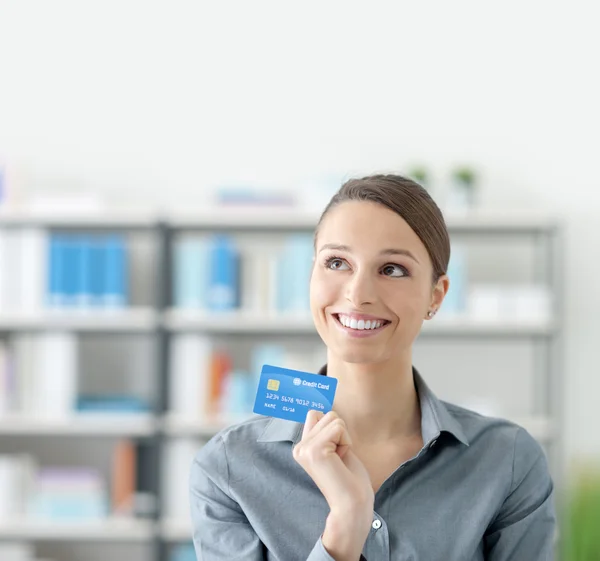 Jeune femme souriante tenant une carte de crédit — Photo