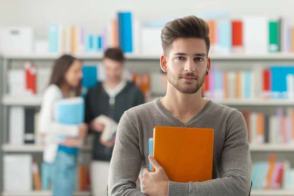 Confident student posing in the library — Stock Photo, Image