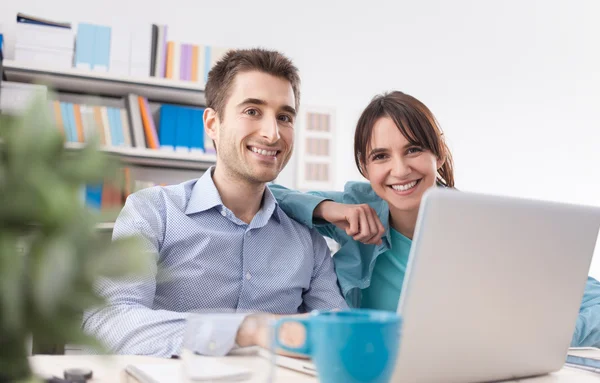 Jovem casal em casa usando um laptop — Fotografia de Stock