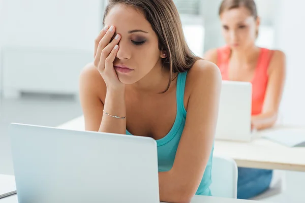 Chica aburrida sentada en el escritorio de la escuela — Foto de Stock