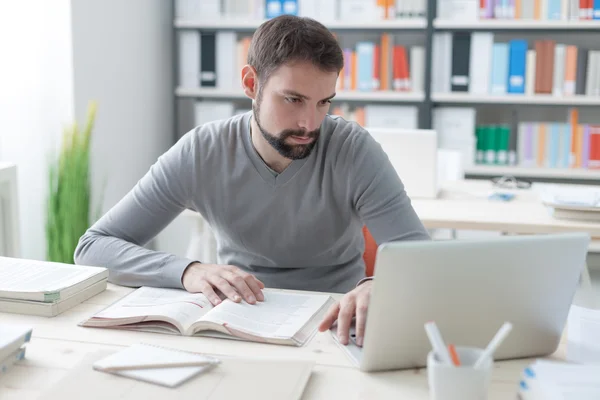 Man studying and connecting with a laptop — Stock Photo, Image