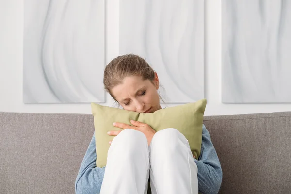 Sad woman hugging a pillow — Stock Photo, Image