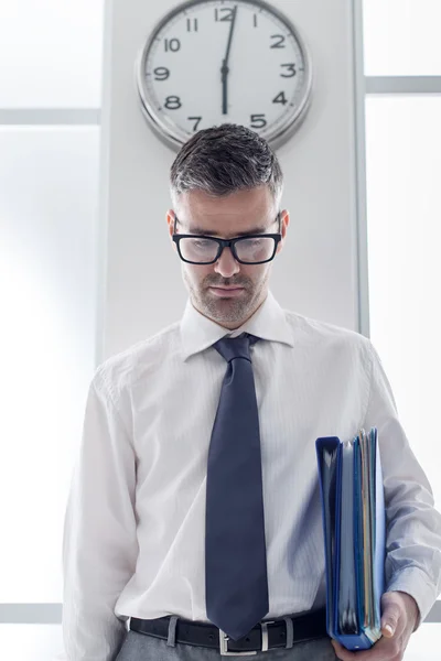 Frustrado hombre de negocios parado bajo un reloj — Foto de Stock