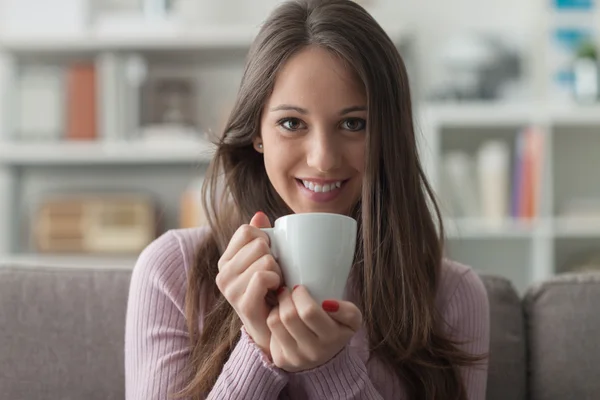 Flicka med en kopp kaffe hemma — Stockfoto