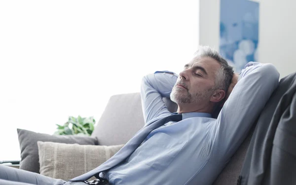 Biznesmen śpi na kanapie — Zdjęcie stockowe