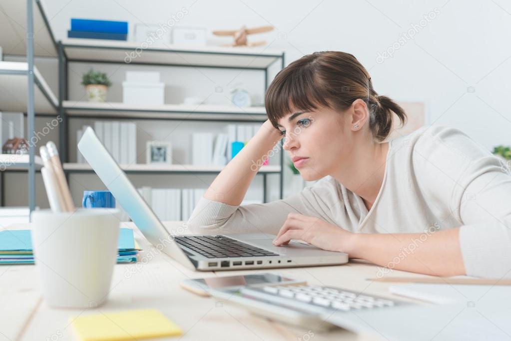 Disappointed woman working with a laptop