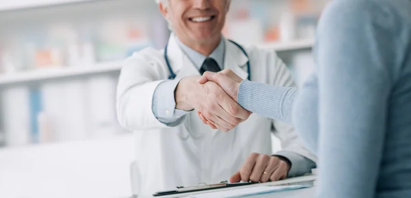Médico y paciente estrechando las manos — Foto de Stock