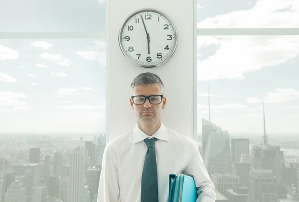 Розроблений бізнесмен стоїть під годинником — стокове фото