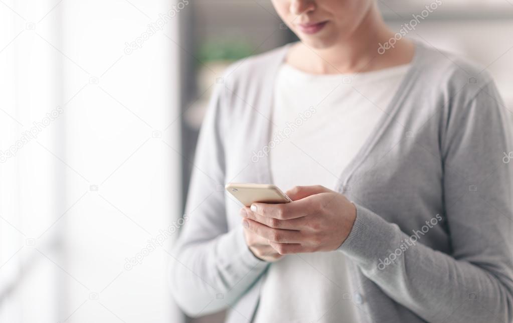 Young woman text messaging with her mobile
