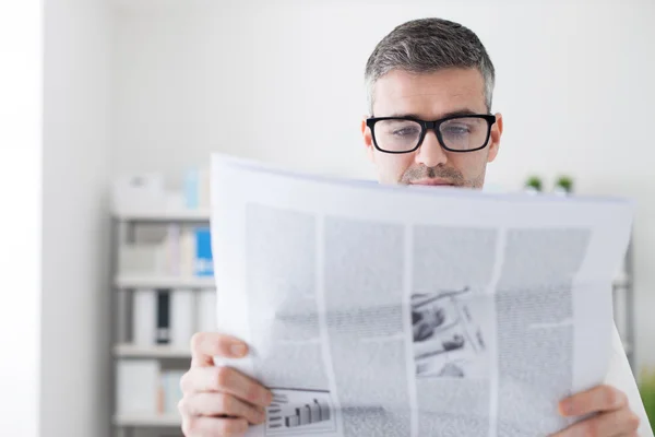 Selbstbewusster Geschäftsmann beim Zeitungslesen — Stockfoto