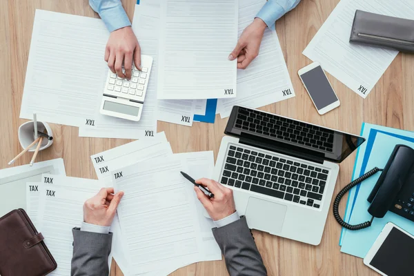 Empresários que verificam formulários fiscais — Fotografia de Stock