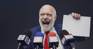 Kötü niyetli politikacı basın toplantısında işaret gösteriyor ve gülüyor.