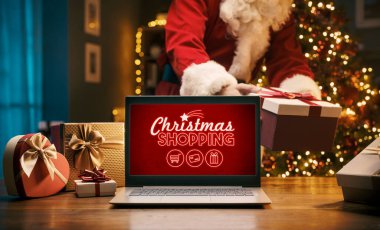 Noel Baba eve bir hediye ve dizüstü bilgisayarla Noel alışveriş reklamı getiriyor.