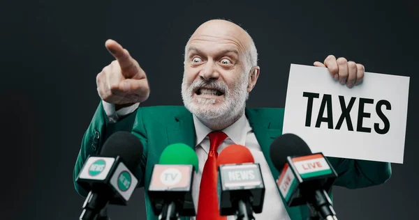 Agressieve Politicus Houdt Een Bord Met Belastingconcept Praat Met Media — Stockfoto