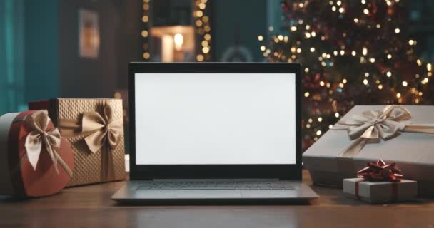 Laptop met blanco scherm en kerstcadeaus — Stockvideo