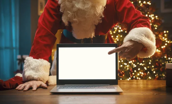 Papai Noel Atrás Uma Mesa Apontando Para Tela Laptop Natal — Fotografia de Stock