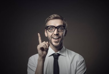 Zeki iş adamının harika bir fikri var ve işi için bir çözüm buluyor, gülümsüyor ve yukarıya doğru işaret ediyor.