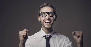 Neşeli mutlu adam yumruklarıyla, başarısıyla ve başarı konseptiyle kutluyor.