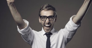 Neşeli mutlu adam yumruklarıyla, başarısıyla ve başarı konseptiyle kutluyor.