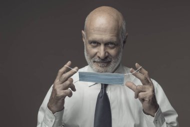 Orta yaşlı şirket işadamı koruyucu yüz maskesi takıyor, Coronavirus covid-19 önleme