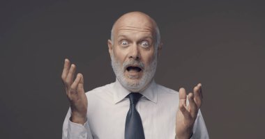 Shocked scared businessman staring at camera and gasping clipart