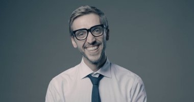 Genç, neşeli iş adamı kameraya gülümsüyor, mutlu ve rahat.