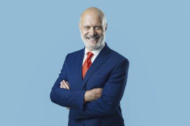 Gülümseyen iş adamı kollarını kavuşturarak poz veriyor.