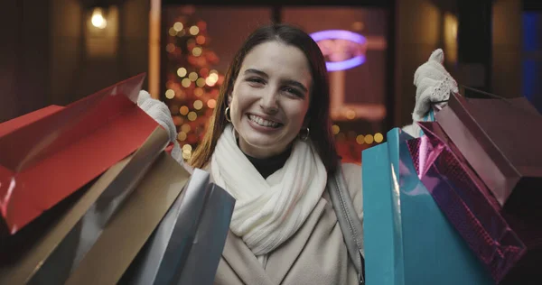 陽気な幸せな女性はクリスマスの買い物をして 彼女は袋をたくさん持っていると笑顔 — ストック写真