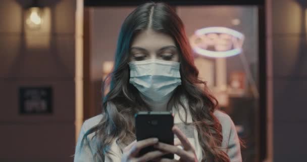 戴着外科口罩并与手机连接的妇女 — 图库视频影像