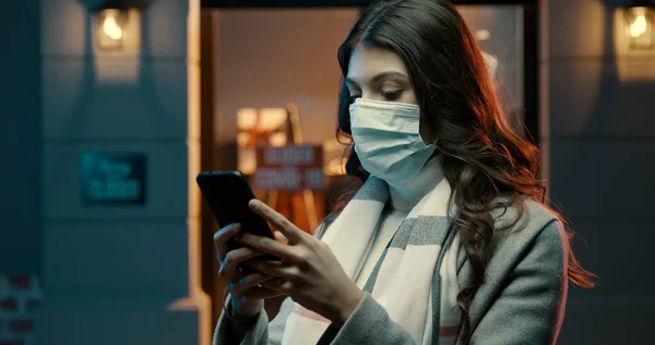 Mladá Žena Městě Ulici Nosí Chirurgickou Masku Spojuje Svým Smartphonem — Stock fotografie