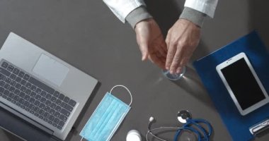Doktor ellerine dezenfektan sürüyor.