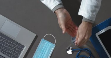 Doktor ellerine dezenfektan sürüyor.