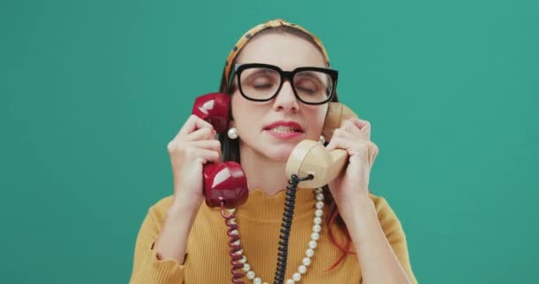 Funny woman talking on two phones. — Stock video