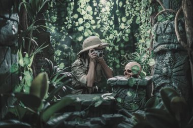 Ormanı keşfeden ve fotoğraf makinesiyle fotoğraf çeken cesur kadın eski kalıntıları ve insan kafatasını bulur.