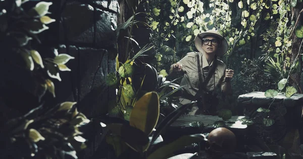 Korkak kâşif ormanda antik kalıntılar buluyor. Elinde bir palayla yürüyor.